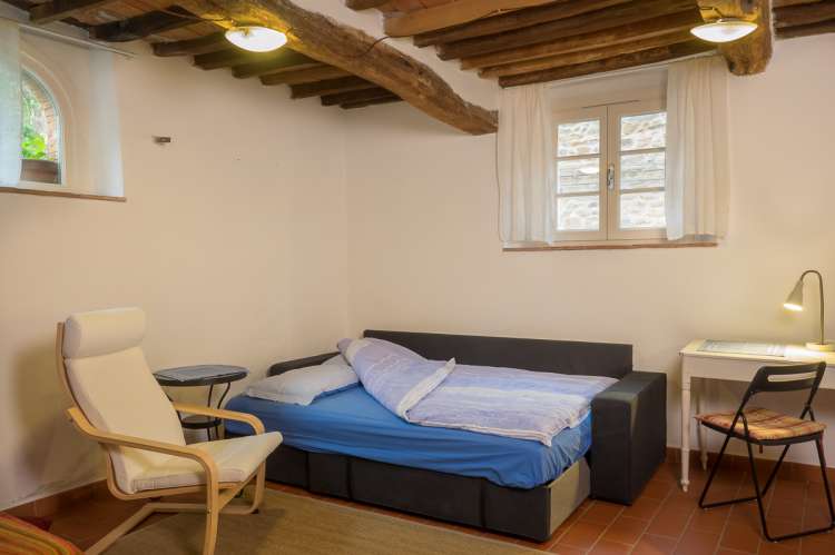 Bildet viser sovesofa i ferieleiligheten Karine midt i middelalderlandsbyen Montemagno ved Pisa.