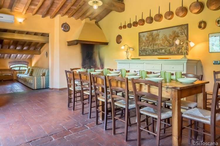 Bildet viser kjøkken med langbord og stue i ferieleiligheten Casa Diana i toskansk landsby.