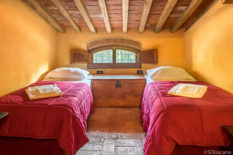 Bildet viser soverom med to senger i ferieboligen Casa Diana i landsby ved Pisa og Lucca.