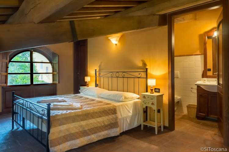 Bildet viser soverom med dobbeltseng i feriehuset Casa Diana med privat basseng i landsby ved Pisa.