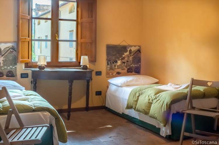 Bildet viser soverom med to senger i ferieboligen Casa Diana i landsby ved Pisa og Lucca.