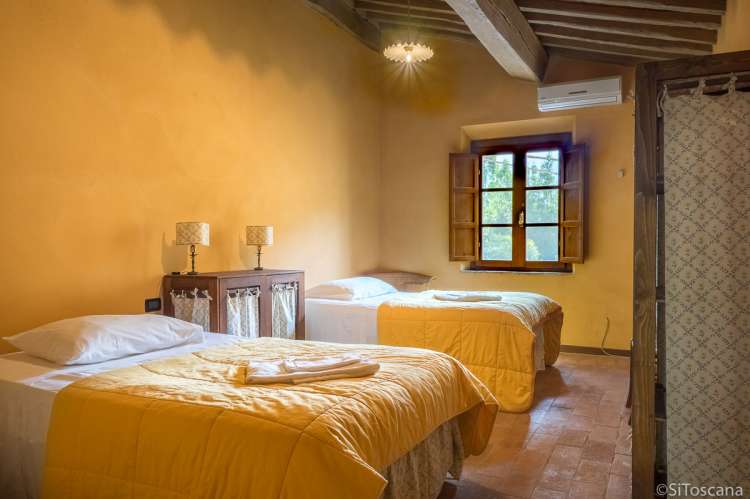 Bildet viser soverom med to store senger i ferieleiligheten Casa Diana ved Pisa.