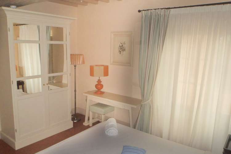 Bildet viser soverom med dobbeltseng i feriebolig ved kysten, nært Pisa i Italia.