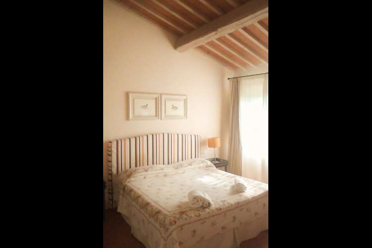 Bildet viser soverom med toskanske takbjelker i Toscana.