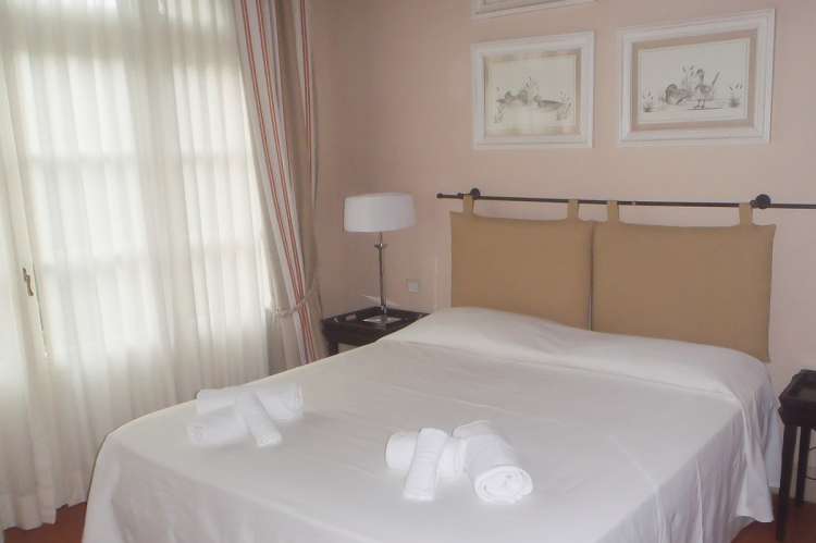 Bildet viser dobbeltseng i ferieleilighet nært kysten og Pisa i Italia.