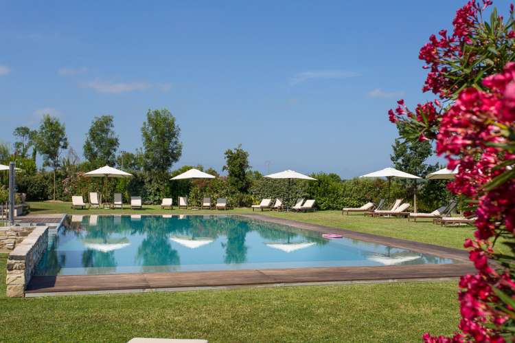 Bildet viser basseng og gressplen på feriebosted nært Pisa i Italia.