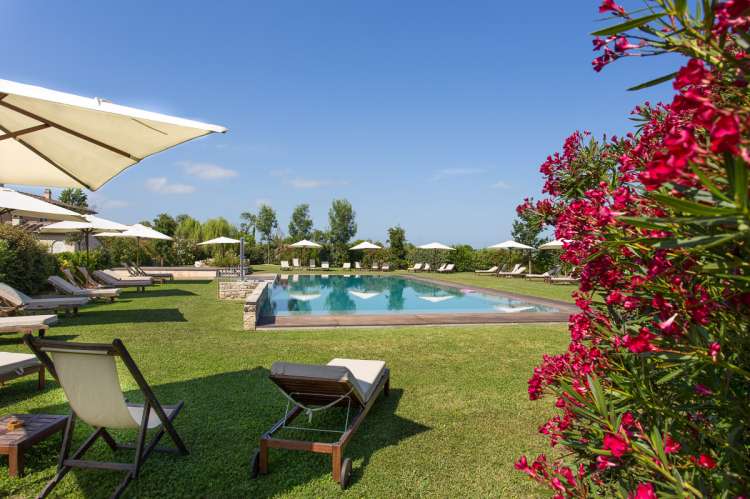 Bildet viser basseng og blomster på feriebosted nært Pisa og strender i Toscana.