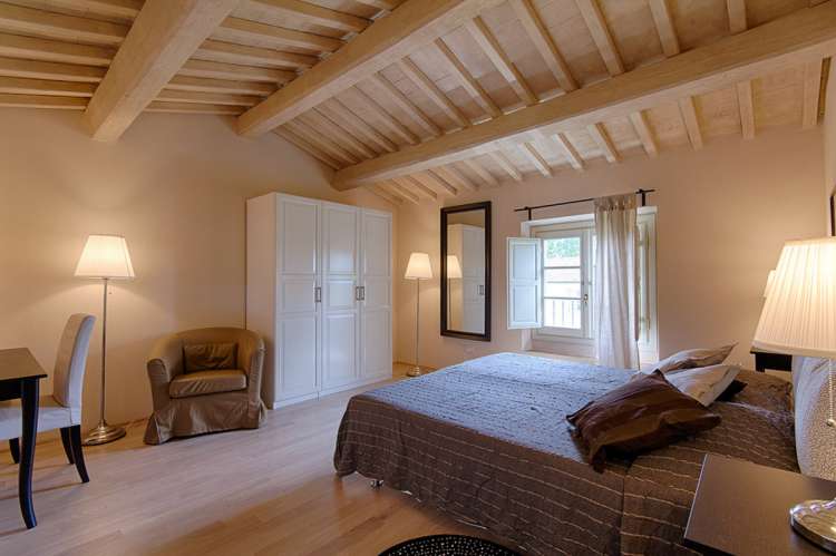 Bildet viser soverom med dobbeltseng i feriehus nært Lucca i Toscana.