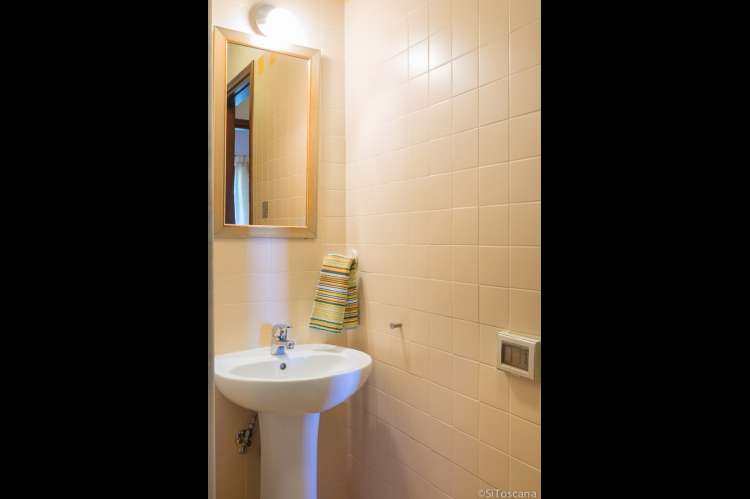 Fra badet i underetasjen. Bildet av vask og speil på badet i nederste etasje i feriehuset Casetta Livia.