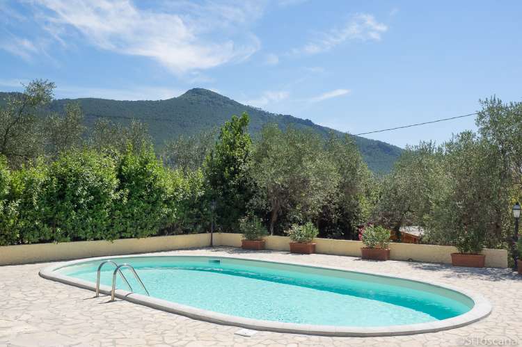 Bildet viser basseng med utsikt til fjell i feriehuset Casa Rosa i Toscana.