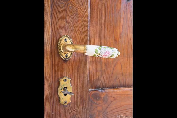 Bildet viser dekorert dørhåndtak i ferieboligen Casa Rosa like utenfor Pisa.