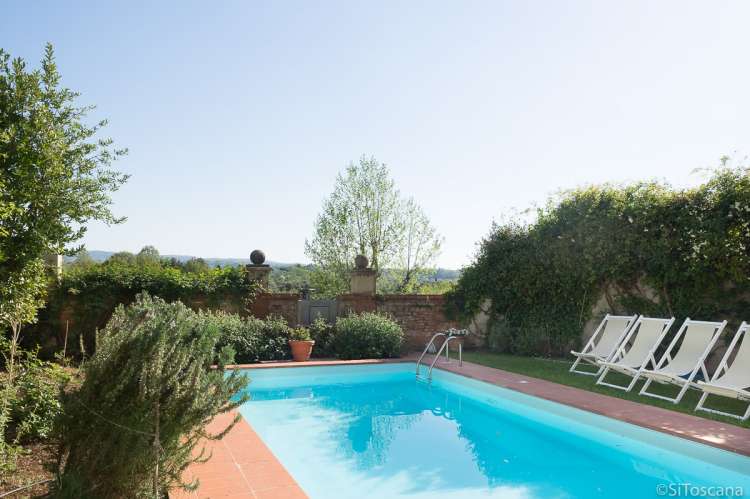 Bildet viser basseng i frodige omgivelser i eksklusiv villa i Toscana.