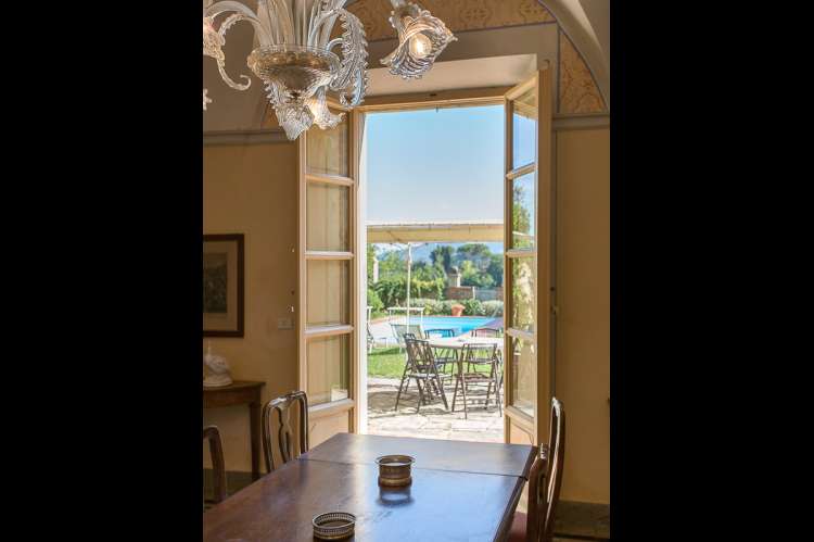 Bildet viser spisestue med utsikt mot basseng og hage ved feriehuset Palazzo Pietro. Huset ligger i Toscana mellom Pisa og Firenze.