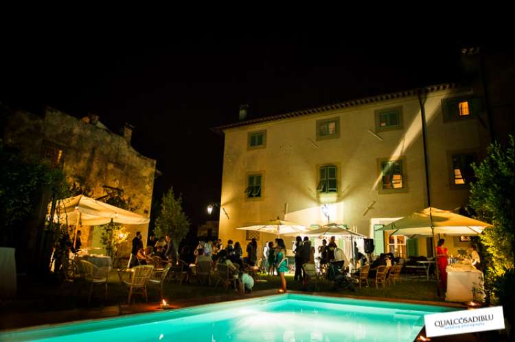 Bildet viser hage og basseng ved feriehuset Palazzo Pietro. Det er kveld og mørkt og hagen er fylt av bryllupsgjester. Huset ligger i Toscana mellom Pisa og Firenze.
