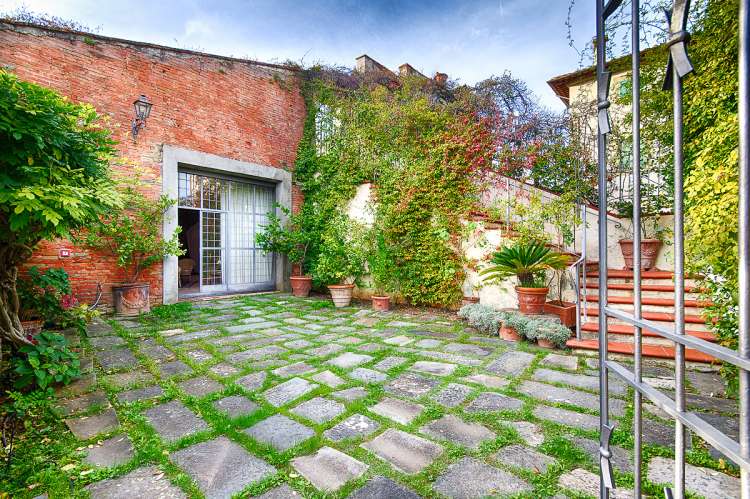 Bildet viser vakker bakgård med blomster i Toscana.