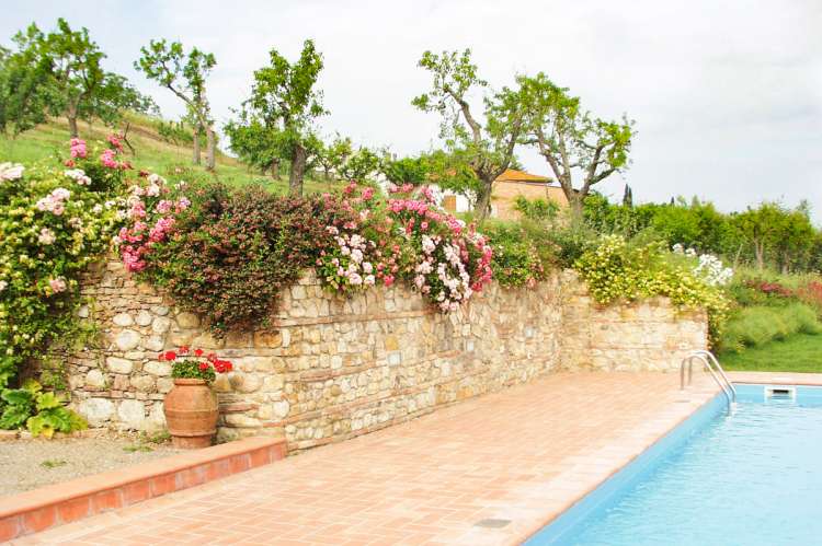 Bildet viser basseng og blomster i feriebolig i landsby i Toscana.