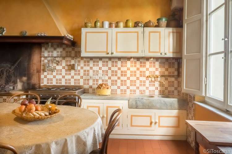 Bildet viser kjøkken med peis og spisebord i villa i Toscana.