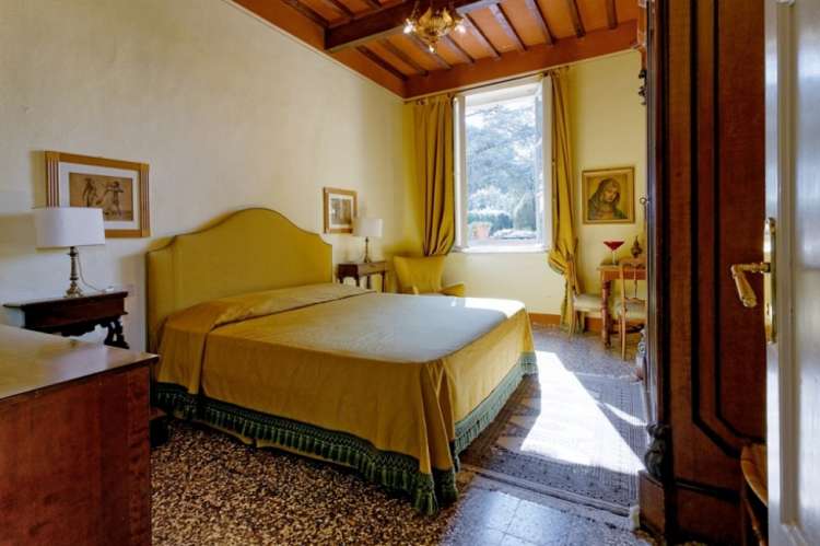 Bildet viser soverom med dobbeltseng i stort feriehus i landsby ved Pisa i Toscana.