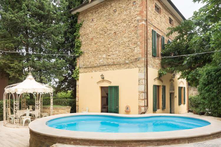 Villa Rustica er i tre etasjer. Bildet viser feriehus med terrasse og basseng i landsby i Toscana.