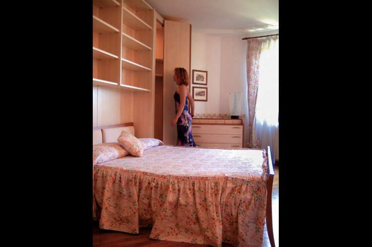 Bildet viser soverom med dobbeltseng i ferieleilighet i landsby nært Pisa i Italia.