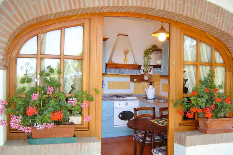 Bildet viser uteplass og kjøkken i feriebolig med basseng nært Pisa.