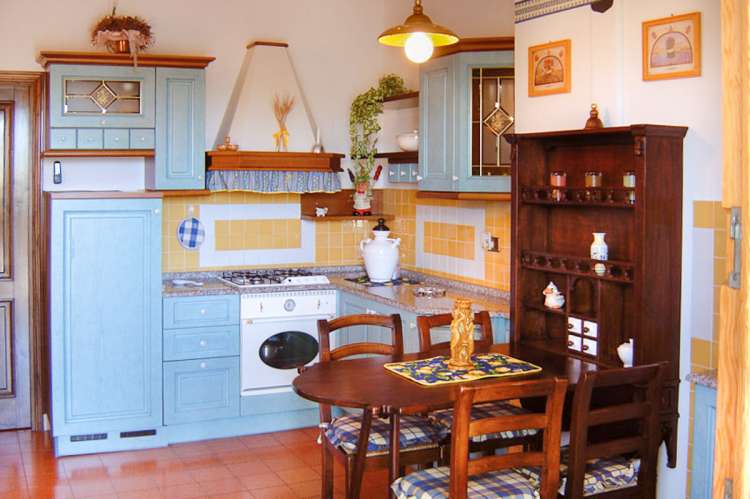Bildet voser kjøkken med spisebord i feriebolig i landsby i Toscana.