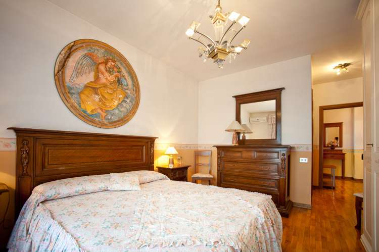 Bildet viser soverom med dobbeltseng i feriebolig i landsby i Toscana.