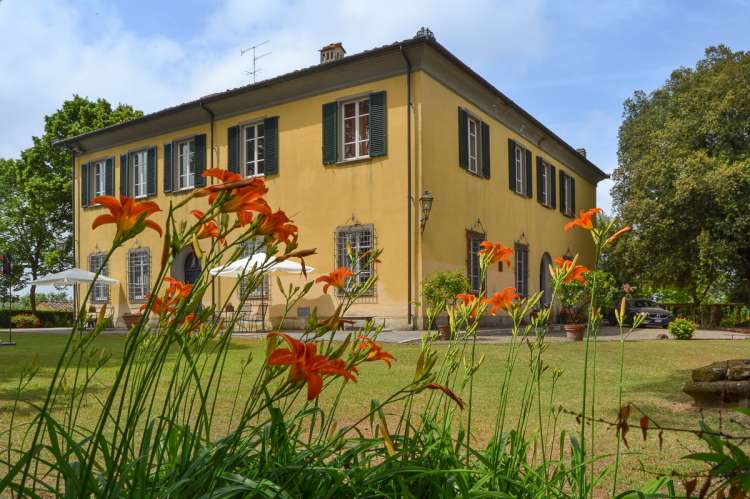 Bildet viser stor villa ved landsby i Toscana.