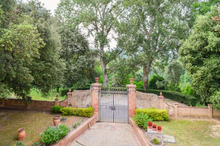 Bildet viser porten og innkjøringen til eiendommen Villa Alba. Her kan man kjøre inn til privat parkering på eiendommen.