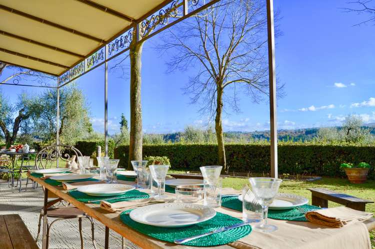 Bildet viser terrassen i Villa Alba med utsikt og et langbord dekket for middag.
