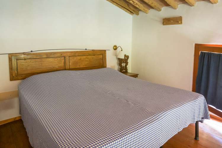 Bildet viser soverom på hems i ferieleilighet på gård med matkurs nært Pisa.
