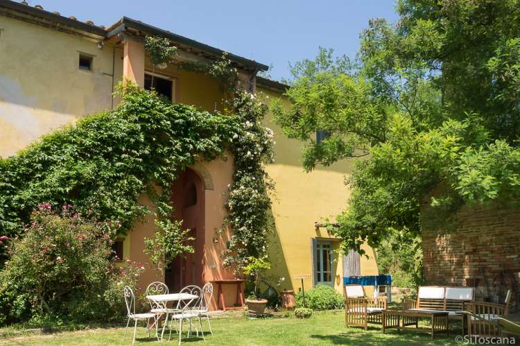 Bildet viser steinhus på olivengård med frokost nært Pisa i Italia.