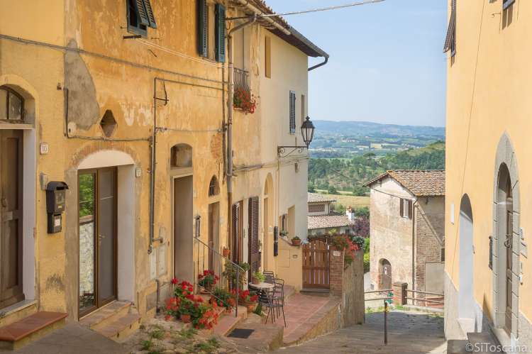Bildet viser utsikt fra gate i middelalderlandsby i Toscana.