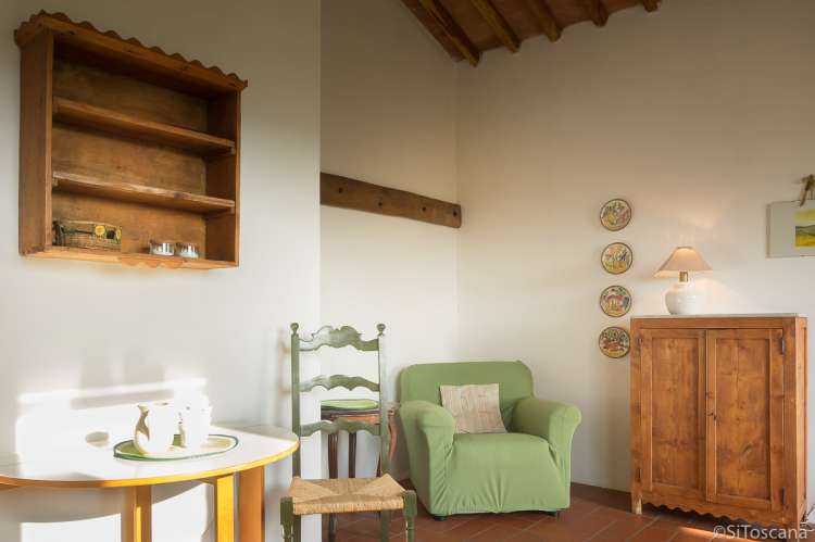 Bildet viser stue i feriebolig med utsikt på gård i Toscana.