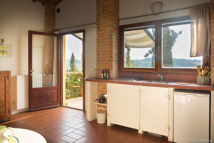 Bildet viser kjøkken med utsikt i feriehus på familievennlig gård ved Pisa i Toscana.