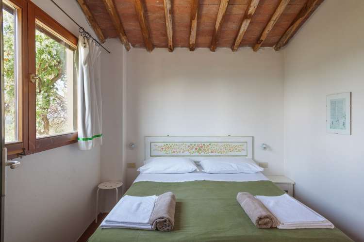 Bildet viser soverom med utsikt i feriehus på barnevennlig gård nært Pisa.