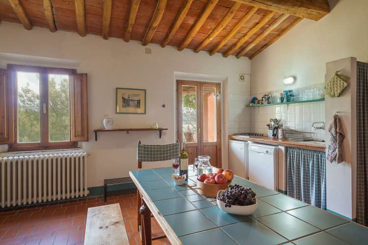Bildet viser kjøkken med langbord i feriebolig på barnevennlig gård nært Pisa.