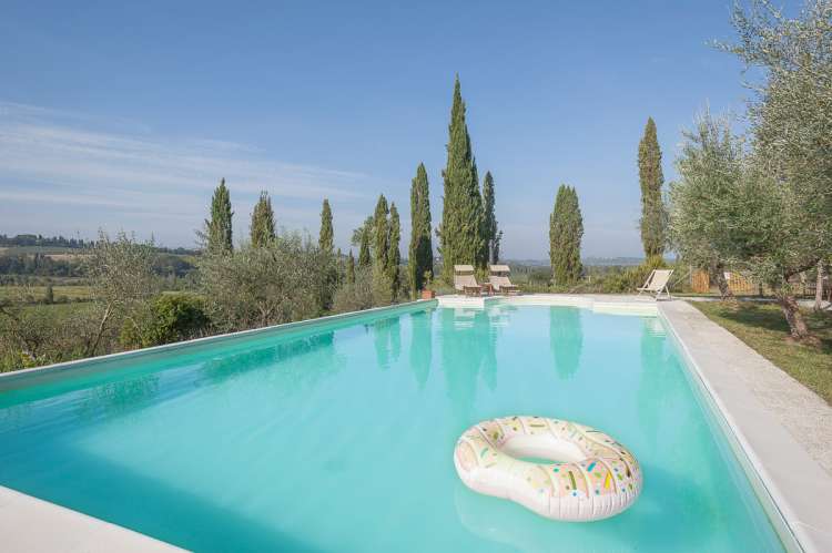 Bildet viser basseng og sypresser på familievennlig gård med ferieleiligheter i Toscana.