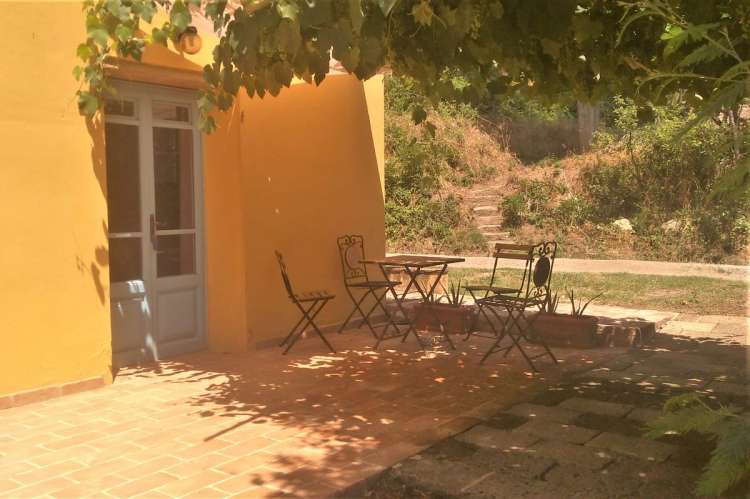 Bildet viser uteplass under pergola på olivengård i Toscana.