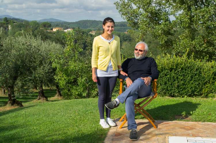 Bilde av vertskapet Giuseppe med datter Elena. Foto med landskapet i Toscana i bakgrunnen.