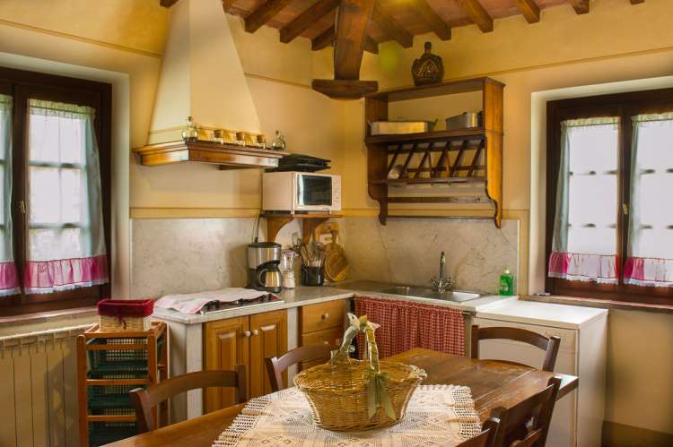 Lyst kjøkken med to vinduer i ferieleiligheten Verde. Foto.