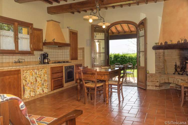 Occhio Bello har direkte utgang fra oppholdsrom/kjøkken til egen uteplass. Foto fra ferieleiligheten Occhio Bello der man ser oppholdsrom med peis og høy kvalitet på møbler. Direkte utgang til terrasse.