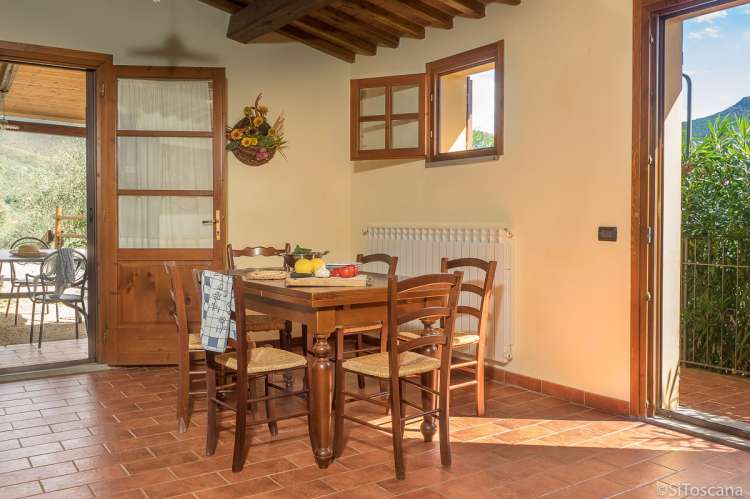 Bildet viser spisebord og utgang til terrasse i ferieboligen Villa Vista ved landsby i Toscana.