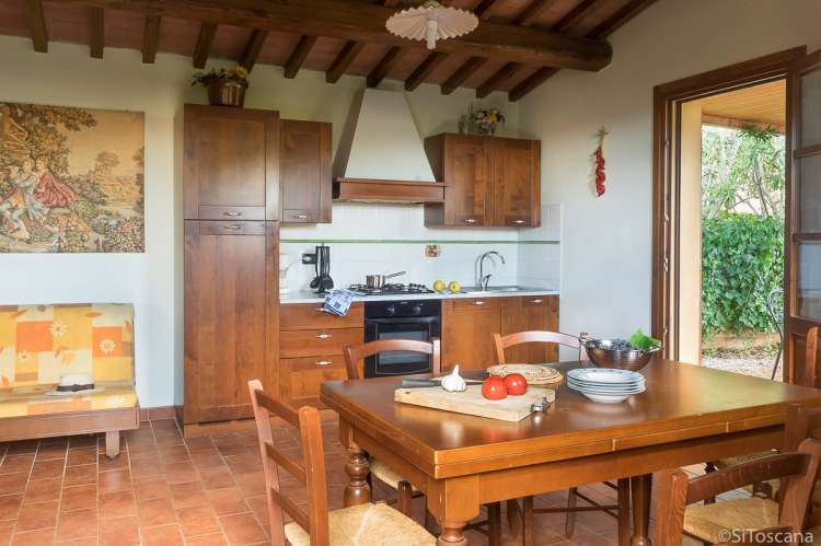 Bildet viser kjøkken og spisebord med utgang til terrasse i feriehuset Villa Vista i Toscana.