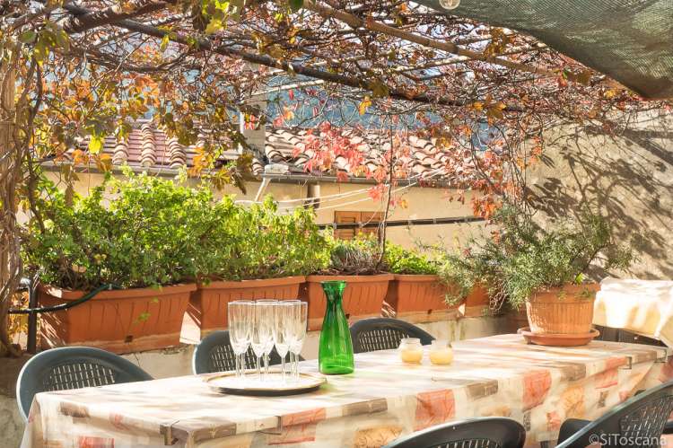 Bildet viser spisesbord på terrasse i ferieleilighet i landsby i Toscana.