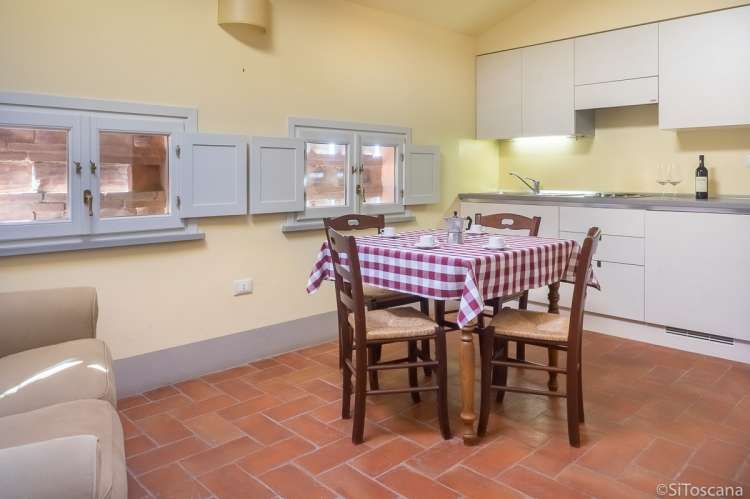 Bildet viser kjøkken og spisebord i ferieboligen Baciamano på vingård i Toscana.