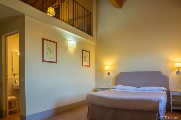 Bildet viser soverom med hems og bad i feriebolig på vingård ved Pisa i Toscana.