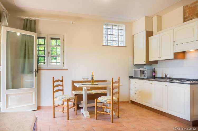 Bildet viser oppholdsrom med kjøkken i ferieleiligheten Nido på vingården Borgo Etruschi. Formidlet av SiToscana.