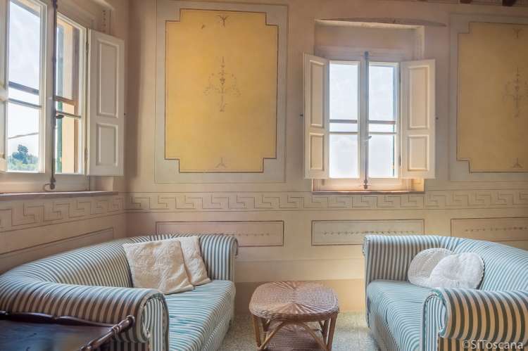 Bildet viser stue og veggmalerier i feriebolig ved Pisa.