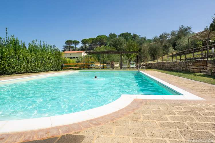 Bildet viser barn i basseng på feriebosted i Toscana.